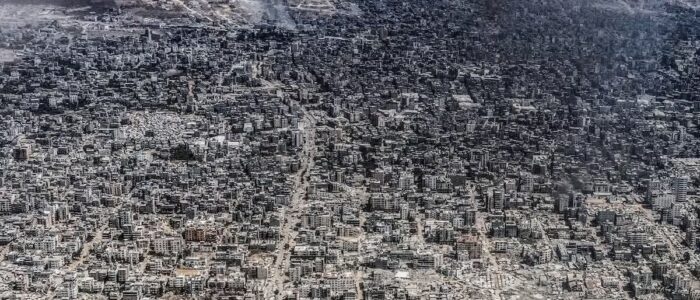 Vista aerea di una città, Gaza, con ampie aree distrutte e fumo in lontananza
