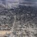 Vista aerea di una città, Gaza, con ampie aree distrutte e fumo in lontananza