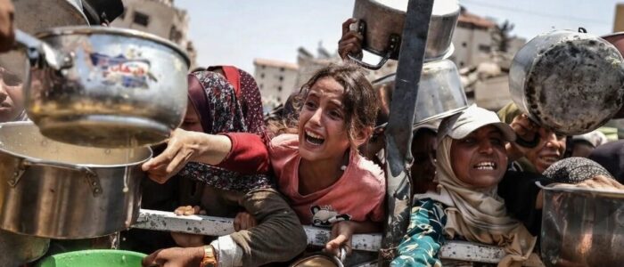 Ogni giorno a Gaza, persone in fila con pentole e recipienti per ricevere