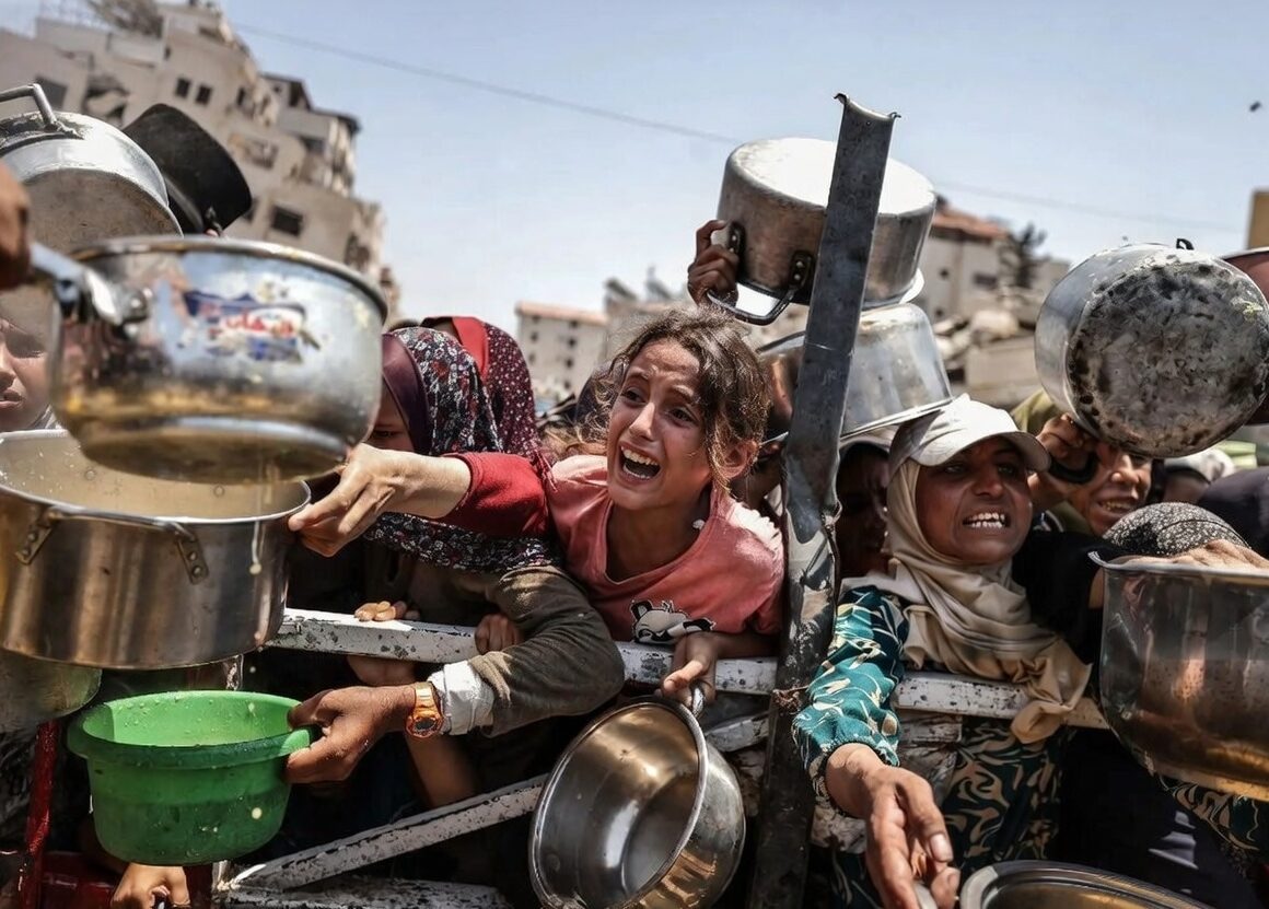 Ogni giorno a Gaza, persone in fila con pentole e recipienti per ricevere